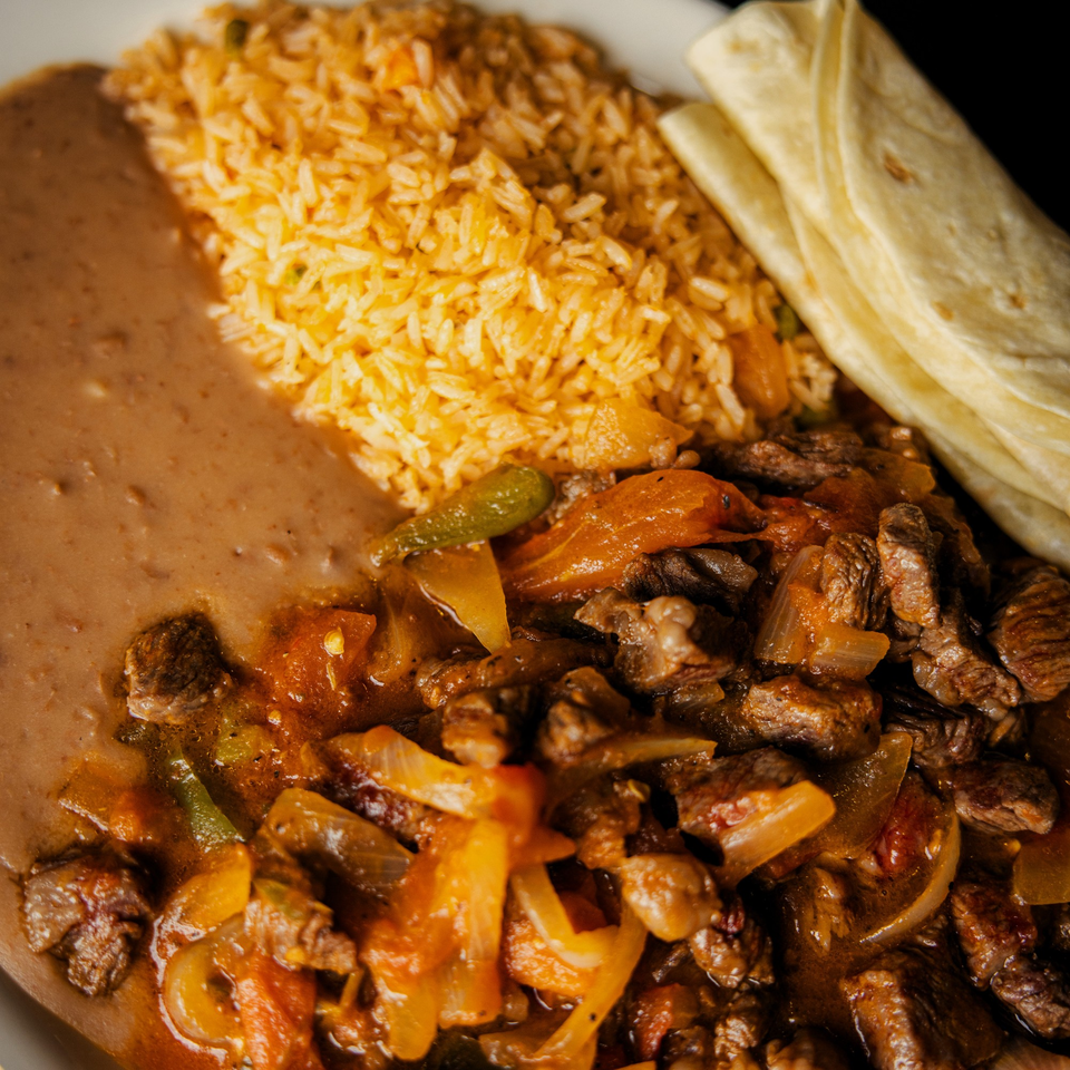 La Casa del Sol's Mexican dish with beef, rice, beans, and tortillas on a white plate.